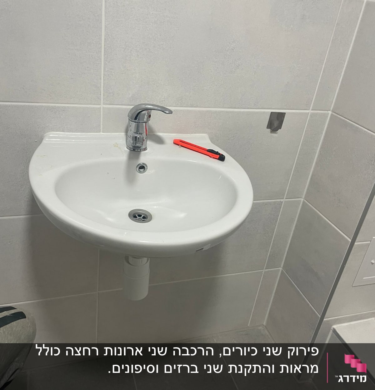 כיור עם ברז וסכין יפנית על השיש
